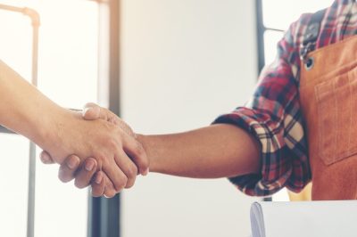 Two carpenters holding hands, The concept of working together until success